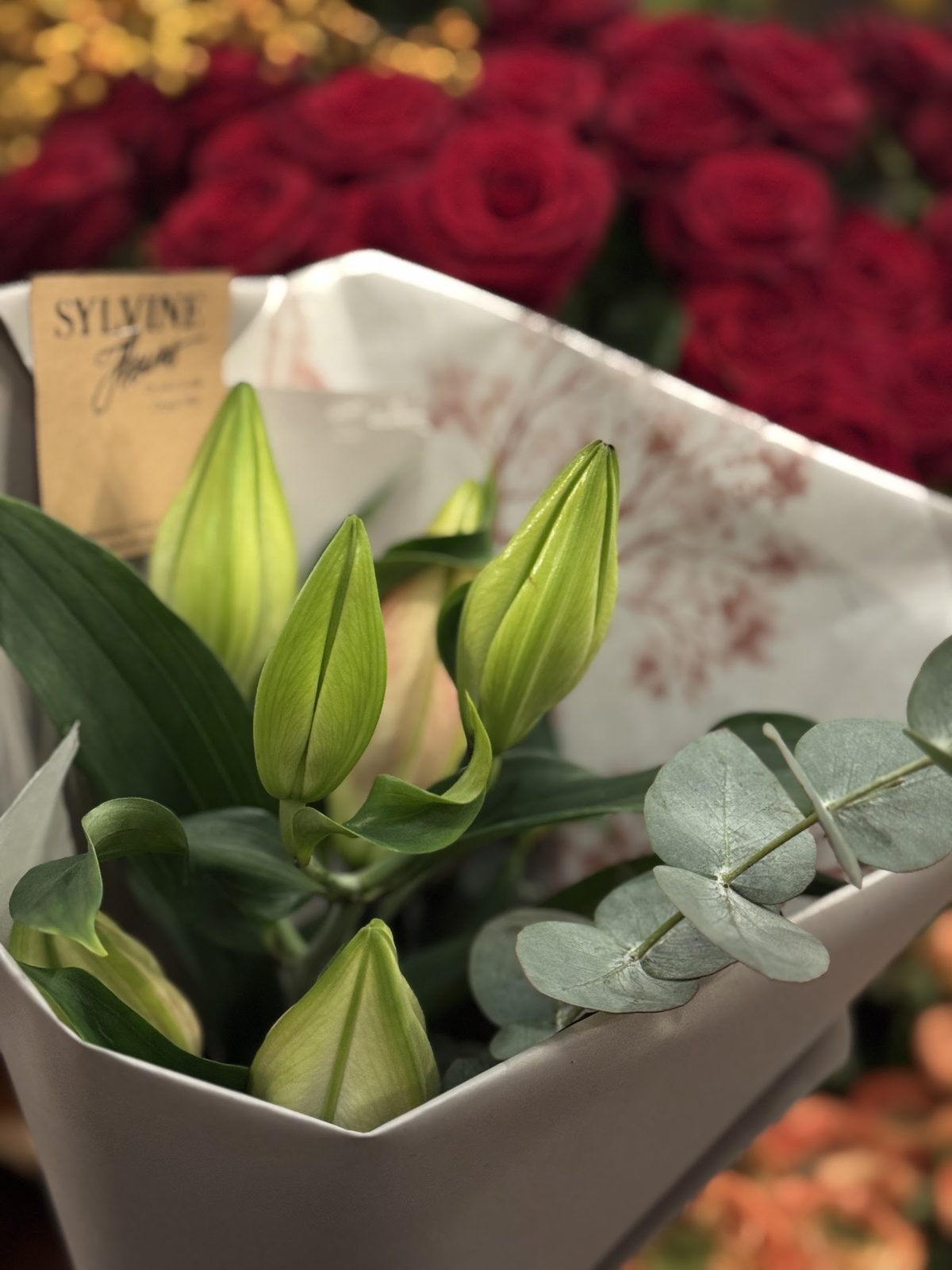Lys blancs et eucalyptus dans le papier Sylvine Fleurs