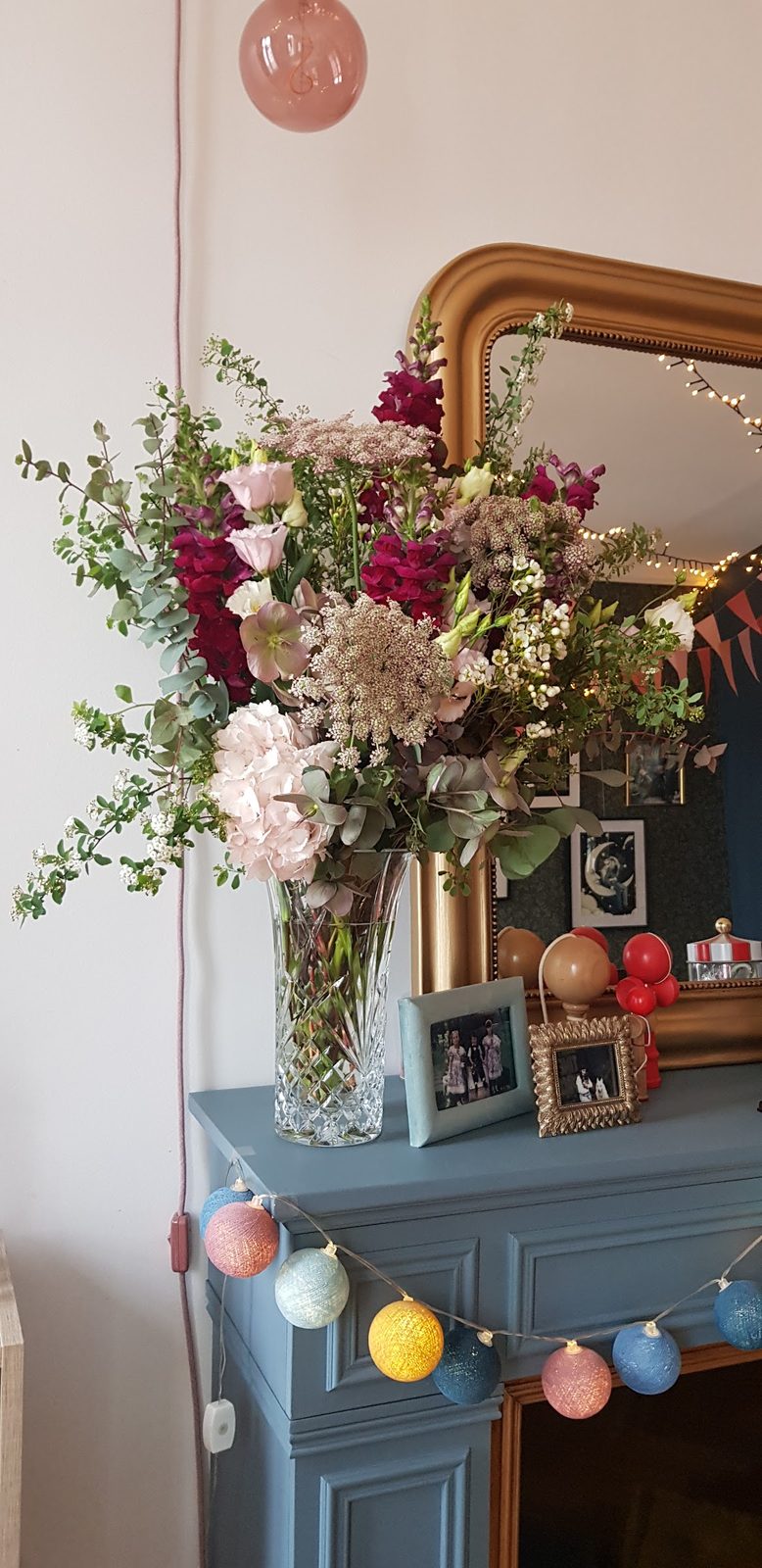 Bouquet posé sur la console bleue, sous le miroir de la boutique